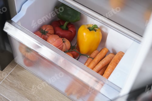 Preview: Fresh vegetables in the drawer of the opened fridge.