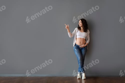 Preview: Look There. Happy Young Pregnant Female Pointing Aside At Copy Space