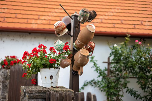 Preview: Several ceramic cups stored hanging on a fence in village in Hungary