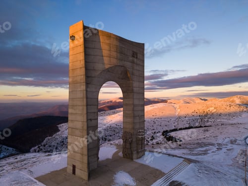 Preview: Beautiful aerial view of snow covered mountains and the Monument Arch of Liberty at the main ridge