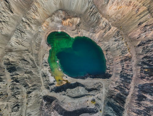 Preview: Close-up aerial view of a turquoise lake in an open-pit mine
