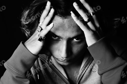 Preview: Grayscale shot of a young Indian man's serious face