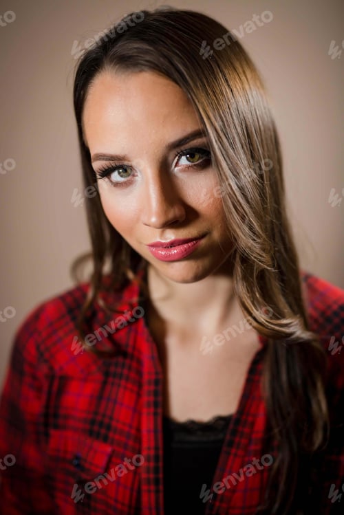 Preview: Vertical portrait of a brunette female in a flannel shirt against a brown background