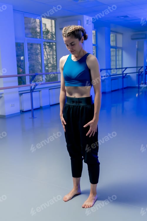 Preview: in studio of spiritual development master class girl standing meditates in a blue top and black