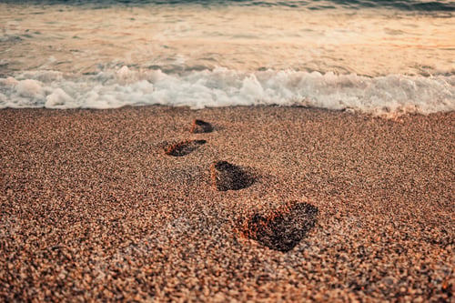 Preview: Footprint on sand with foam in the morning
