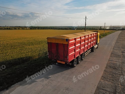 Preview: Modern bright truck on road near wheat field
