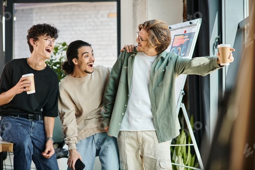 Preview: young man in 20s showing something to excited startup team and looking away in a bright future