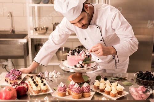Preview: portrait of confectioner decorating cake in restaurant kitchen