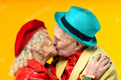 Preview: Beautiful senior old couple wearing fancy party clothes acting in studio on a colored background.