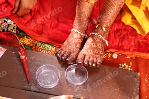 Preview: Close-up shot of the legs of an Indian bride wearing leg chain applied mehndi