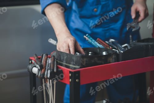 Preview: Professional car mechanics searching for auto repair tools in tool racks, all kinds of auto speciali