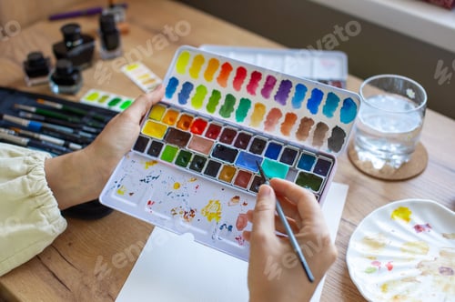 Preview: Artist Painting with Watercolor Palette on Wood Table