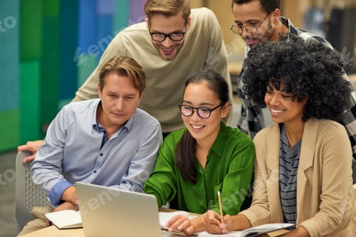 Preview: Group of happy multiracial business people sitting at desk in the modern coworking space, looking at