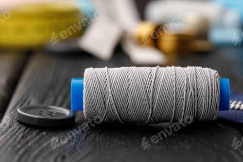 Preview: Colorful sewing utensils on black wooden surface