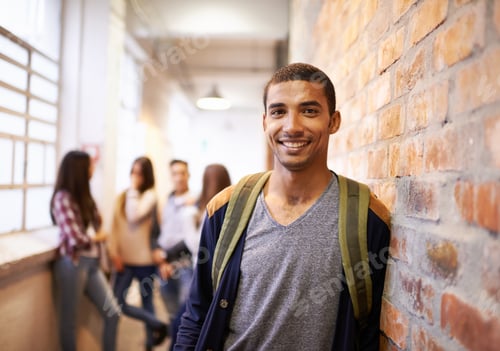 Preview: Portrait of a handsome young male student leaning against a wall with his friends in the background