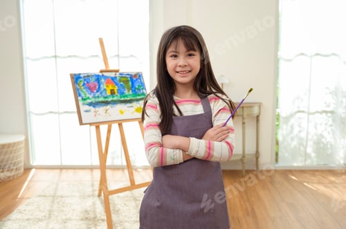 Preview: Child Creates Art While Standing at an Easel in a Bright Room During Daytime