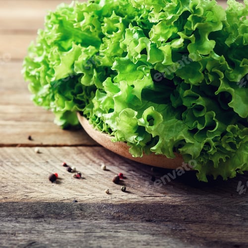 Preview: Fresh organic lettuce salad on wooden background with pepper. Healthy food, raw and vegetarian