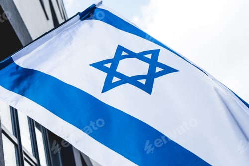 Preview: low angle view of national israel flag with star of david near building against sky