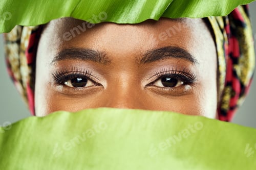 Preview: Shot of a beautiful young woman covering herself with a plant