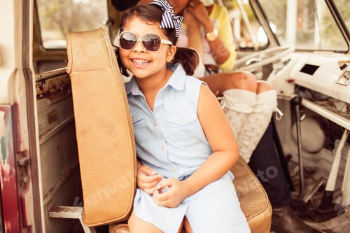 Preview: Young girl enjoying a sunny day in a vintage van