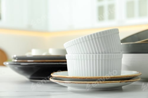 Preview: Set of ceramic tableware on white table in kitchen, closeup