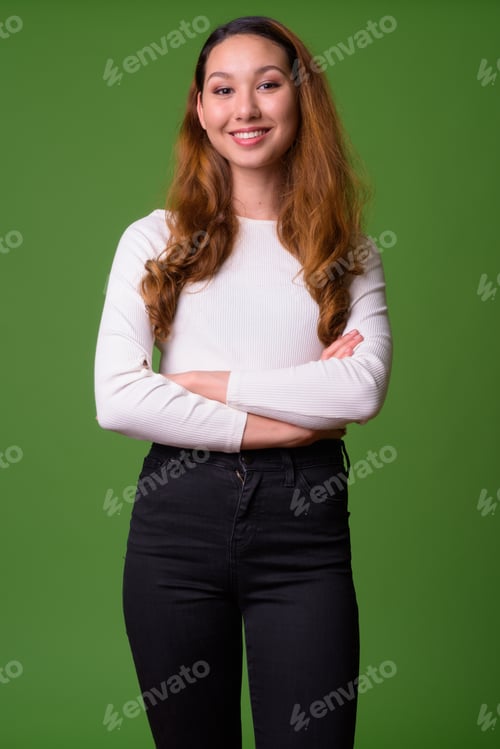 Preview: Young beautiful Asian woman against green background