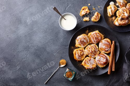 Preview: Cinnamon rolls on black plate. Grey background. Copy space. Top view.