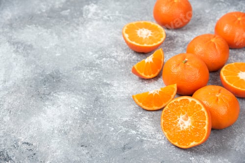 Preview: Whole and slice juicy fresh orange fruits placed on a stone background