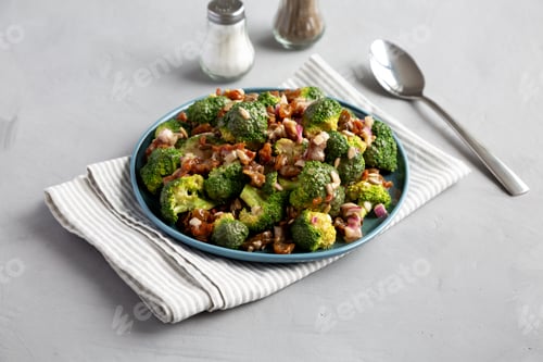 Preview: Homemade Broccoli Bacon Salad on a Plate on a gray background, side view.