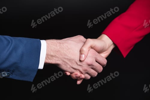 Preview: Close-up partial view of man and woman shaking hands isolated on black