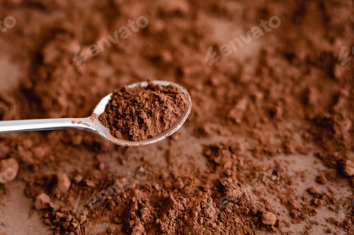 Preview: High angle view of cocoa in spoon and on brown background