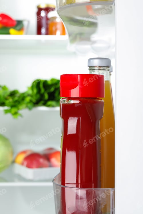 Preview: Bottles with different tasty sauces and products in fridge, closeup