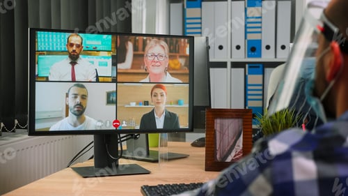 Preview: Handicapped business man with mask talking online with colleagues