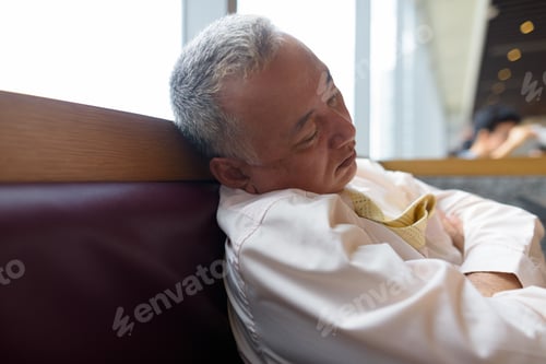 Preview: Mature Asian businessman relaxing inside the restaurant