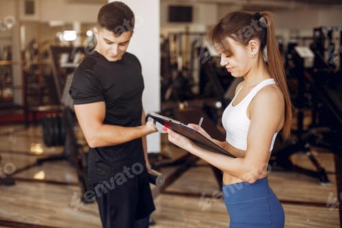 Preview: A beautiful sports couple is engaged in a gym