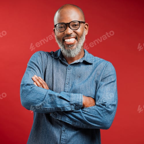 Preview: One mature African American man with his arms crossed isolated against a red studio background. Por
