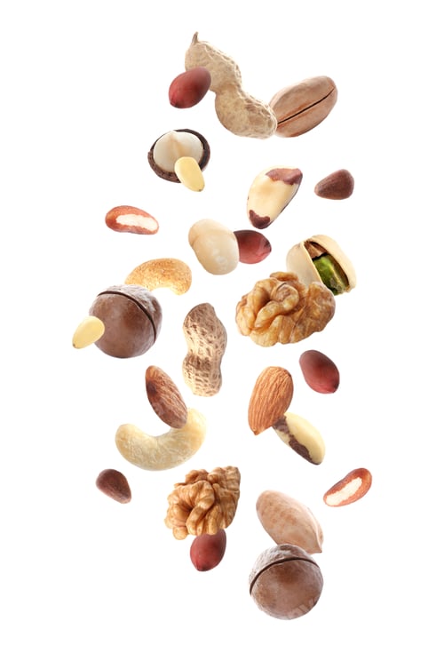 Preview: Different nuts falling on white background