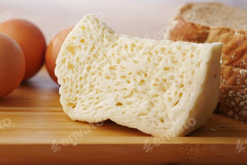 Preview: Close up of cheese, milk , brown bread and almond nut on table.