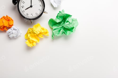 Preview: Alarm clock with crumpled paper balls.Timing and thinking idea concept.