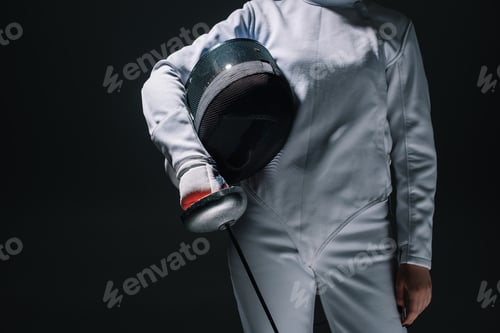 Preview: Cropped view of fencer holding fencing mask and rapier isolated on black