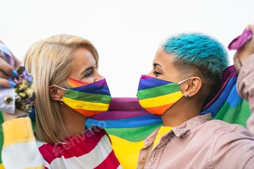 Preview: Happy gay couple wearing face mask celebrating gay pride event during corona virus pandemic