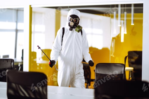 Preview: Disinfecting of office to prevent COVID-19, Man in protective hazmat suit with spray chemicals.