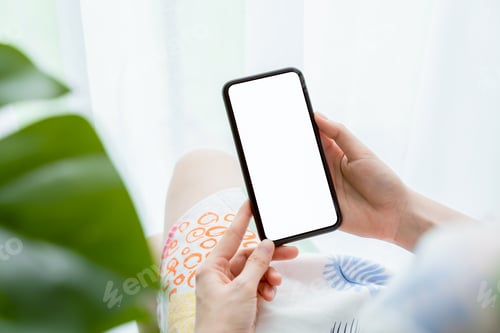 Preview: Hand holding smartphone mockup of blank screen on the table. Take your screen to put on advertising.
