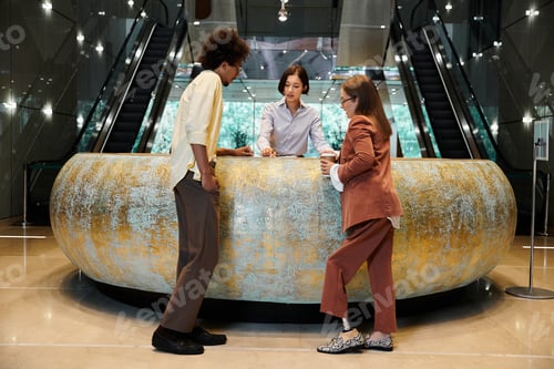 Preview: Diverse colleagues chatting in office lobby