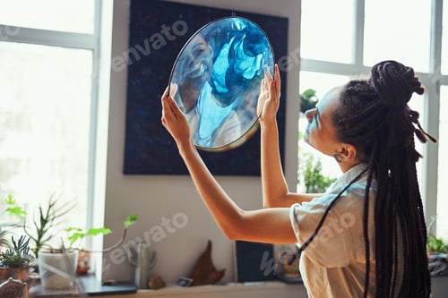 Preview: Painter holding a fluid art picture in her hands