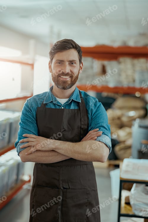 Preview: Smiling business owner standing on the background of own coffee roasting factory