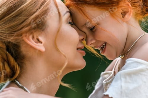 Preview: close-up portrait of beautiful happy mother and daughter touching foreheads and smiling