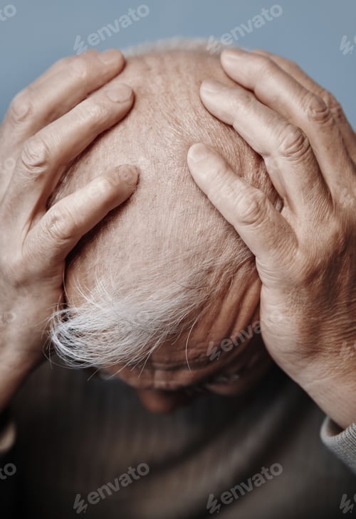 Preview: Senior man holding her head in pain while feeling headache