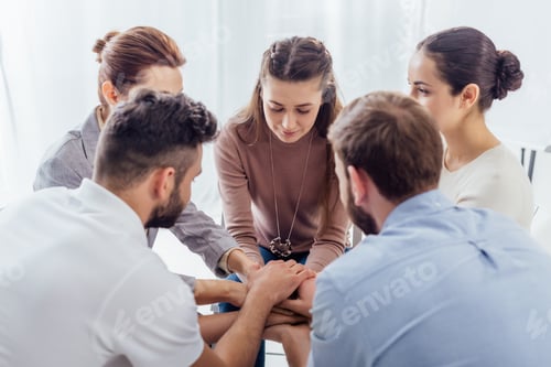Preview: people sitting stacking hands during group therapy session