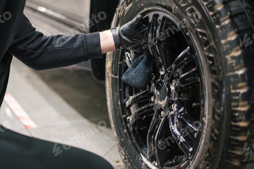 Preview: Closeup of a mechanic performing a detailed tire cleaning on a car's rim, using specialized tools